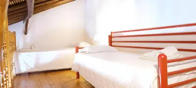 two beds in a room with white walls and wooden floors at Quinta do Lagar - 01 in Albufeira