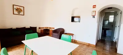 a living room with a white table and green chairs at Quinta do Lagar - 02 in Albufeira