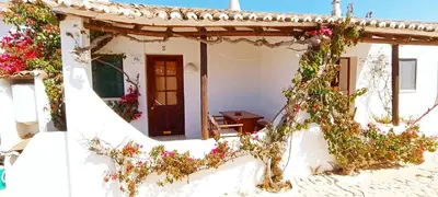 a small white house with flowers on it at Quinta do Lagar - 03 in Albufeira