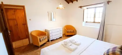 a bedroom with a bed and a chair and a window at Quinta do Lagar - 03 in Albufeira