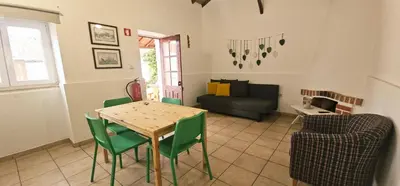 a living room with a table and green chairs at Quinta do Lagar - 04 in Albufeira