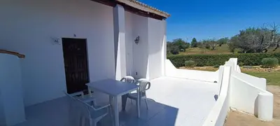 a small table and chairs on a patio with a door at Quinta do Lagar - 09 in Albufeira