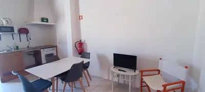 a small kitchen with a white table and chairs at Quinta do Lagar - 09 in Albufeira