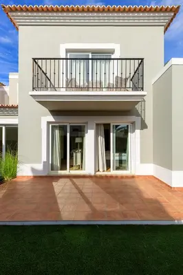 a white house with a balcony and a patio at V4 Duplex Quinta do Lago Sal in Quinta do Lago