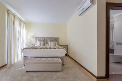 a white bedroom with a large bed and a window at V4 Duplex Quinta do Lago Sal in Quinta do Lago