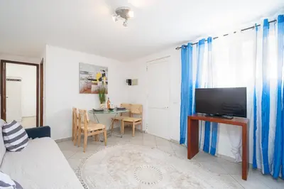 a living room with a couch and a tv and a table at Casa Biamar in Albufeira