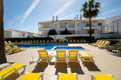 a group of yellow chairs and a swimming pool at Casa Biamar in Albufeira