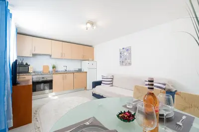 a kitchen and living room with a table and a couch at Casa Biamar in Albufeira