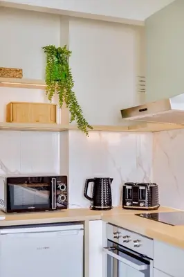 a kitchen with white appliances and a microwave at Brisa Algarvia 2 in Faro