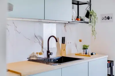 a kitchen with white cabinets and a sink at Brisa Algarvia 2 in Faro