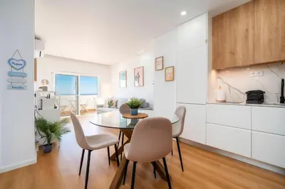 a kitchen and dining room with a table and chairs at Ocean View Apartment Steps to Beach Vil15m Faro25m in Quarteira