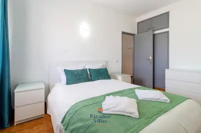 a white bedroom with a bed and a window at Cozy 1-Bedroom Apartment, Pool, Central Albufeira in Albufeira