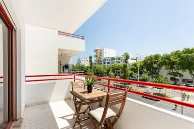 a balcony with a wooden table and two chairs at SunnyQuarters WalktoBeach 2BR AC