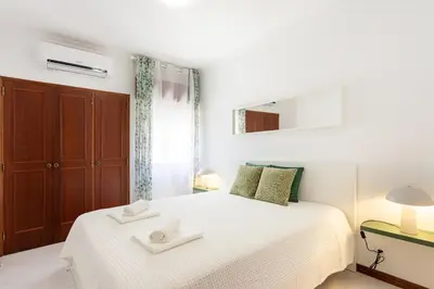 a bedroom with a white bed with towels on it at SunnyQuarters WalktoBeach 2BR AC