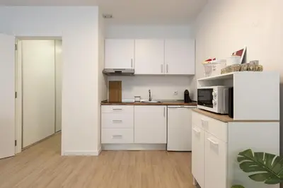 a kitchen with white cabinets and a microwave at Maya Vilamoura - City center by HD PROPERTIES in Vilamoura