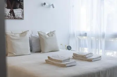 a white bed with three folded towels on it at Maya Vilamoura - City center by HD PROPERTIES in Vilamoura