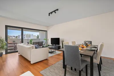 a dining room and living room with a table and chairs at Rooftop Pools & Balcony Haven by HostWise in Faro