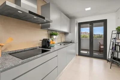 a kitchen with white cabinets and a counter top at Rooftop Pools & Balcony Haven by HostWise in Faro
