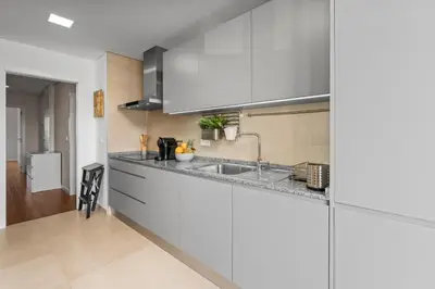 a kitchen with white cabinets and a sink at Rooftop Pools & Balcony Haven by HostWise in Faro