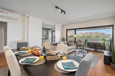 a dining room and living room with a table and chairs at Rooftop Pools & Balcony Haven by HostWise in Faro