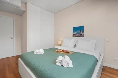 a bedroom with a bed with towels and shoes on it at Rooftop Pools & Balcony Haven by HostWise in Faro