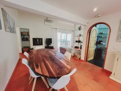 a dining room with a wooden table and white chairs at Golf&Mar By Garvetur Villas in Loulé