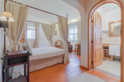 a bedroom with a bed and a bathroom at Golf&Mar By Garvetur Villas in Loulé