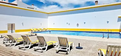 a group of chairs and a swimming pool at Fantástico T2 Perto da Praia da Falésia, Albufeira in Albufeira