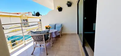 a balcony with a table and chairs on a balcony at Fantástico T2 Perto da Praia da Falésia, Albufeira in Albufeira