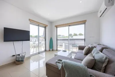 a living room with a couch and a flat screen tv at Casa A in Olhos de Água