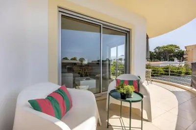 a balcony with a white couch and a table and chairs at Casa A in Olhos de Água