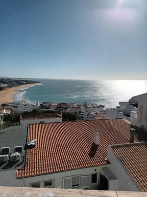 a view of the ocean and the roofs of buildings at Apartamento Alto de Abufeira in Albufeira