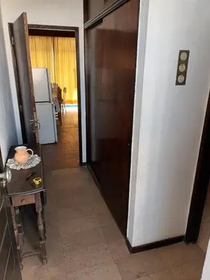 a hallway with a door and a table and a refrigerator at Apartamento Alto de Abufeira in Albufeira
