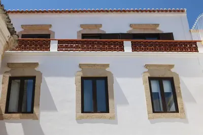 two windows on the side of a white building at Casa Malpique in Albufeira
