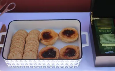 a container of donuts and corn on a table at Casa Malpique in Albufeira