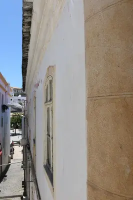 a white building with a window on the side of it at Casa Malpique in Albufeira