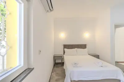 a white bedroom with a bed and a window at #336 Vila Sol by Home Holidays in Sesmarias