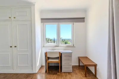 a bedroom with a white bed and a chair at #336 Vila Sol by Home Holidays in Sesmarias