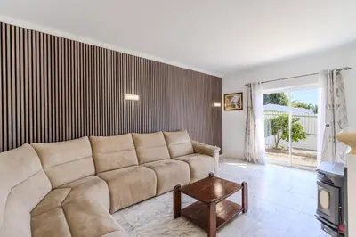 a dining room with a table and chairs and a couch at #336 Vila Sol by Home Holidays in Sesmarias