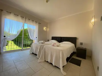 a bedroom with two beds and a large window at Villa 