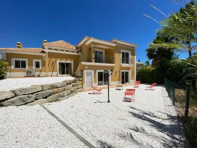 a large house with chairs in front of it at Villa 