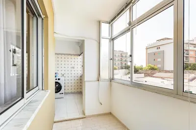an empty room with windows and a washing machine at Amoreira 3br City Center at Homesbyfc in Faro