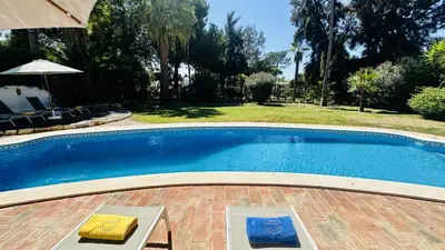 a large swimming pool in a yard with trees at Villa Verde by Check-in Portugal in Vilamoura