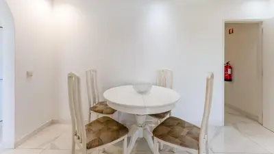 a white table and chairs in a white room at Bright 1BDR Flat in Albufeira by LovelyStay in Albufeira