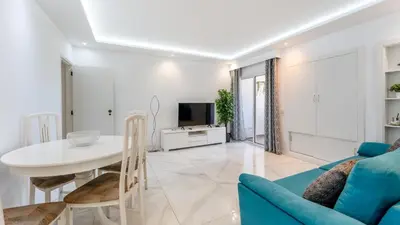 a living room with a blue couch and a white table at Bright 1BDR Flat in Albufeira by LovelyStay in Albufeira