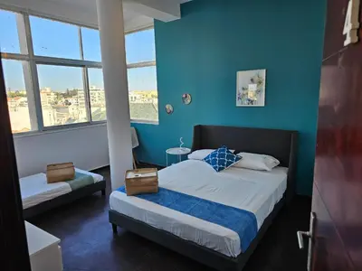 a bedroom with a bed with blue walls and windows at Blife Eduardya - private rooms at Santantonya 5th floor in Faro