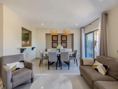 a living room with a table and a dining room at Apartment Pine Hills Diadema-16 by Interhome in Vilamoura