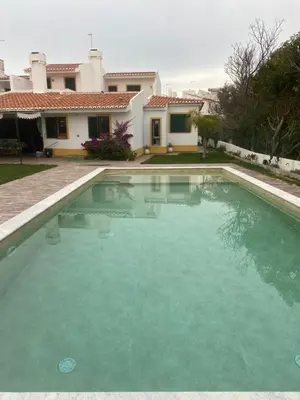 a large swimming pool in front of a house at Villa with pool in the Heart of Oura - Albufeira in Albufeira