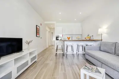 a living room with a couch and a kitchen at Sunshine Apartment in Vilamoura