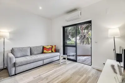 a living room with a couch and a sliding glass door at Sunshine Apartment in Vilamoura